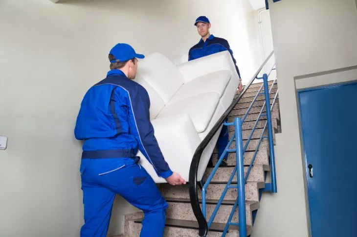 Möbelpacker tragen Sofa übers Treppenhaus Möbelpacker tragen Sofa übers Treppenhaus